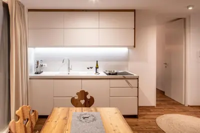 a bedroom with a large white bed and a table at Bellevue Bruneck - Suites & Lofts in Brunico