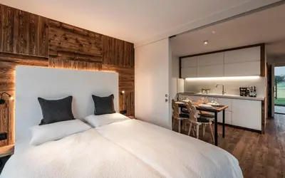 a bedroom with a tub and a bed and a window at Bellevue Bruneck - Suites & Lofts in Brunico