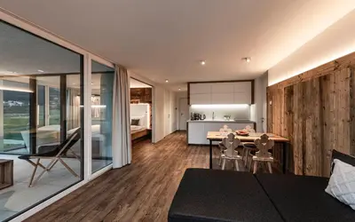 a bed in a room with a wooden wall at Bellevue Bruneck - Suites & Lofts in Brunico