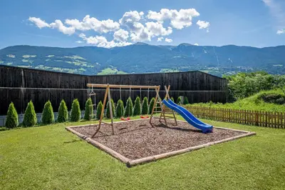 a playground with a slide in a yard at Der Söllhof in Bressanone