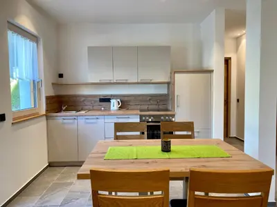 a kitchen with a wooden table and wooden chairs at Der Söllhof in Bressanone