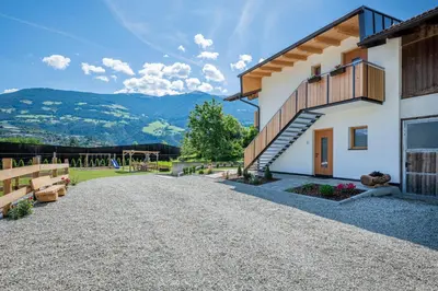 a driveway leading to a house with mountains in the background at Der Söllhof in Bressanone