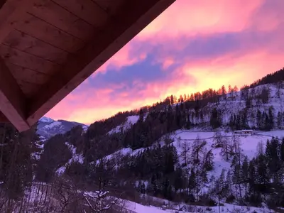 a view of a snow covered mountain with a sunset at B&B Le Stagioni di Stava in Tesero