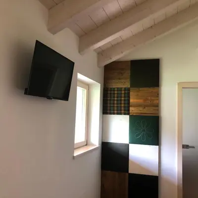 a room with a flat screen tv on the wall at B&B Le Stagioni di Stava in Tesero