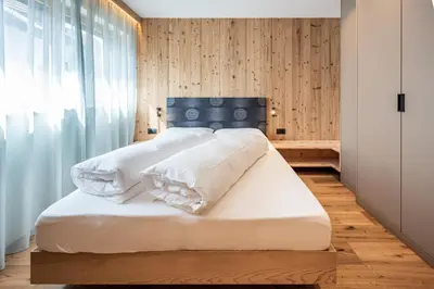 a bedroom with a large white bed with white pillows at Deluxe Appartement Arve in Valdaora