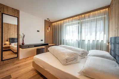 a bedroom with two beds and a large window at Deluxe Appartement Arve in Valdaora