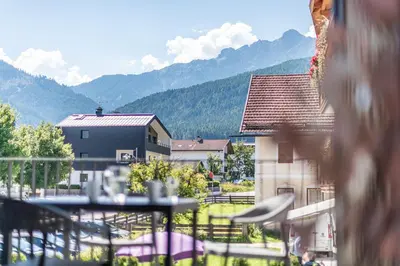 a balcony with a table and a view of mountains at Deluxe Appartement Arve in Valdaora