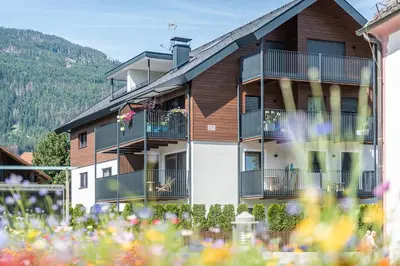 a building with balconies and flowers in front of it at Deluxe Appartement Arve in Valdaora