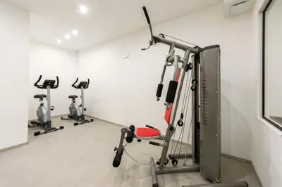 a gym with three exercise bikes in a room at Active Alm Hotel in Moena