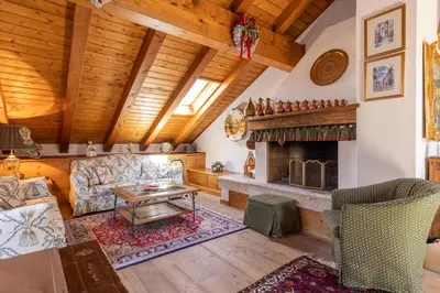 a living room with a couch and a fireplace at Mansarda Belvedere - panoramica e wellness in San Vito di Cadore