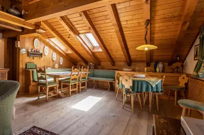 a dining room with a table and chairs in a cabin at Mansarda Belvedere - panoramica e wellness in San Vito di Cadore