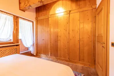 a bedroom with wooden walls and a bed in a room at Mansarda Belvedere - panoramica e wellness in San Vito di Cadore