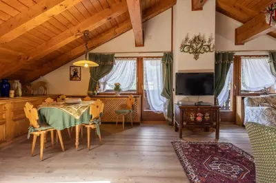 a living room with a table and a tv at Mansarda Belvedere - panoramica e wellness in San Vito di Cadore