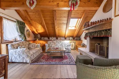 a living room with two couches and a fireplace at Mansarda Belvedere - panoramica e wellness in San Vito di Cadore
