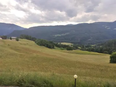 a field of grass with mountains in the background at La casa di Grace nella valle incantantata in Carano