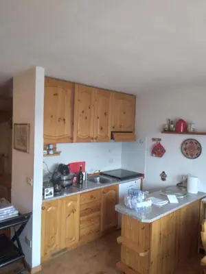 a kitchen with wooden cabinets and a counter top at La casa di Grace nella valle incantantata in Carano
