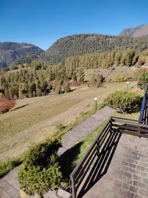 a bench sitting on a stone walkway looking at a mountain at La casa di Grace nella valle incantantata in Carano