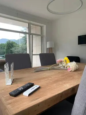 a wooden table with two remote controls and flowers on it at Alps Apartments Viktory in Bolzano