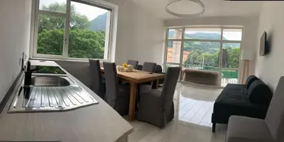 a kitchen and living room with a table and chairs at Alps Apartments Viktory in Bolzano