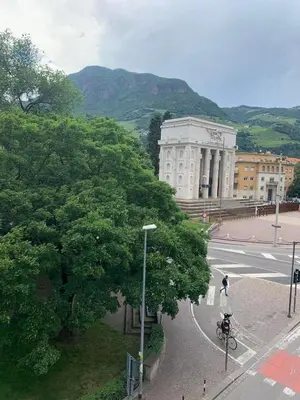 a person riding a motorcycle on a street in front of a building at Alps Apartments Viktory in Bolzano