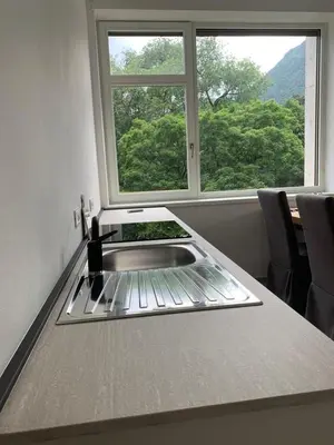 a kitchen counter with a sink and a window at Alps Apartments Viktory in Bolzano