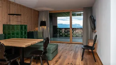 a dining room with a table and chairs and a window at Mountain Lodge Margit in Maranza