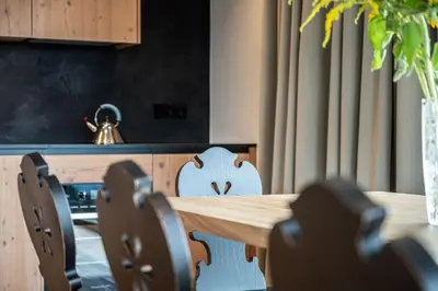a wooden table and chairs in a room at Mountain Lodge Margit in Maranza