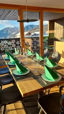 a long wooden table with green napkins and glasses at Mountain Lodge Margit in Maranza