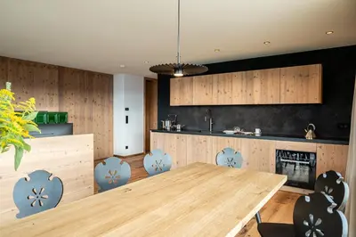 a kitchen with a wooden table and chairs at Mountain Lodge Margit in Maranza