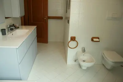 a white bathroom with a toilet and a sink at le stanze di Saraswati in Salorno sulla Strada del Vino