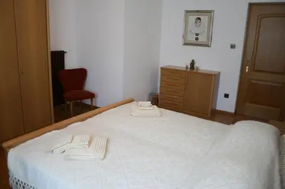 a bedroom with a large white bed with a dresser at le stanze di Saraswati in Salorno sulla Strada del Vino