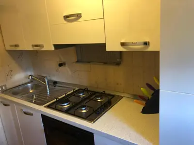 a kitchen counter with a stove and a sink at Case vacanze Desiree in Falcade