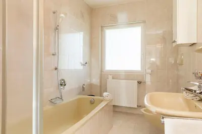 a bathroom with a tub and a sink at Appartement Sonneck in Lappago
