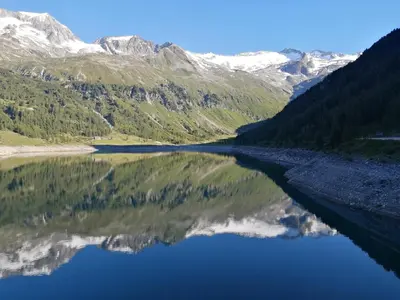 a lake in the mountains with its reflection in the water at Appartement Sonneck in Lappago