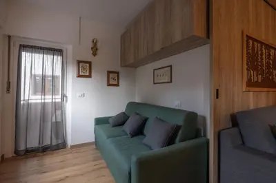 a living room with a green couch and a window at Casa Maia in Cortina dʼAmpezzo