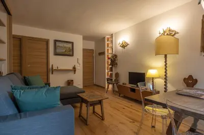 a living room with a blue couch and a table at Casa Maia in Cortina dʼAmpezzo