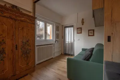 a living room with a blue couch and a window at Casa Maia in Cortina dʼAmpezzo