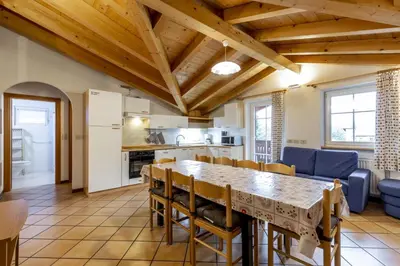 a kitchen and dining room with a table and chairs at Casa Riz in Campitello di Fassa