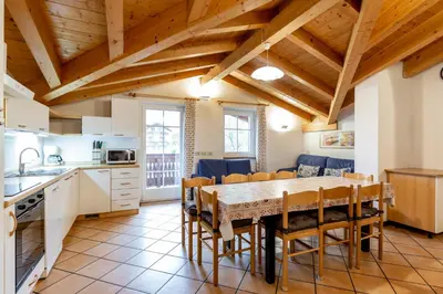 a kitchen with a dining room table and chairs at Casa Riz in Campitello di Fassa