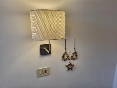 a lamp with earrings hanging on a wall at Casa Riz in Campitello di Fassa