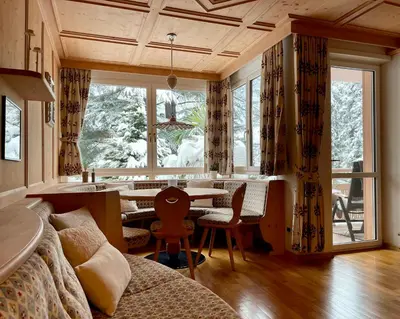a room with a bed and a table and a window at App. Franziska Villa Fabbrani in Bressanone