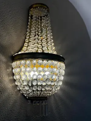 a chandelier is hanging on a wall at Appartamento incantevole Fondo Val di Non in Fondo