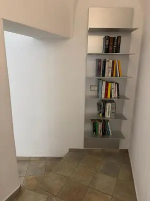 a room with a book shelf filled with books at Appartamento incantevole Fondo Val di Non in Fondo
