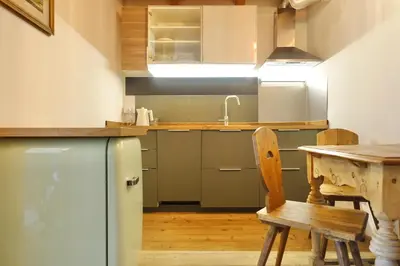 a table and chairs in a room with a window at Apartments DA LA VEDLA Flats in San Cassiano