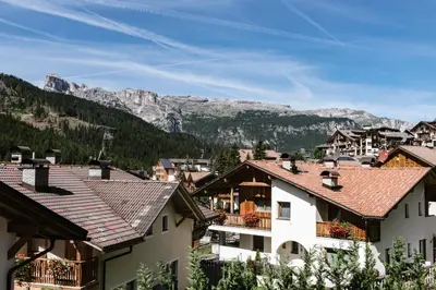 a picture on the wall above a couch with a pillow at Apartments DA LA VEDLA Flats in San Cassiano