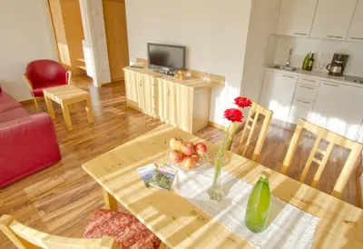 a living room with a table with a vase of flowers at Zagler Appartments in Tirolo