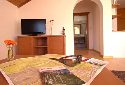 a map and a magazine on a table in a living room at Zagler Appartments in Tirolo