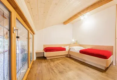 two beds sitting in a room with a window at Zagler Appartments in Tirolo