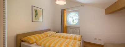 two pillows on a bed in a room with a window at Haus Pobitzer in Caldaro