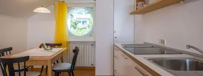 a kitchen with a sink and a table with chairs at Haus Pobitzer in Caldaro